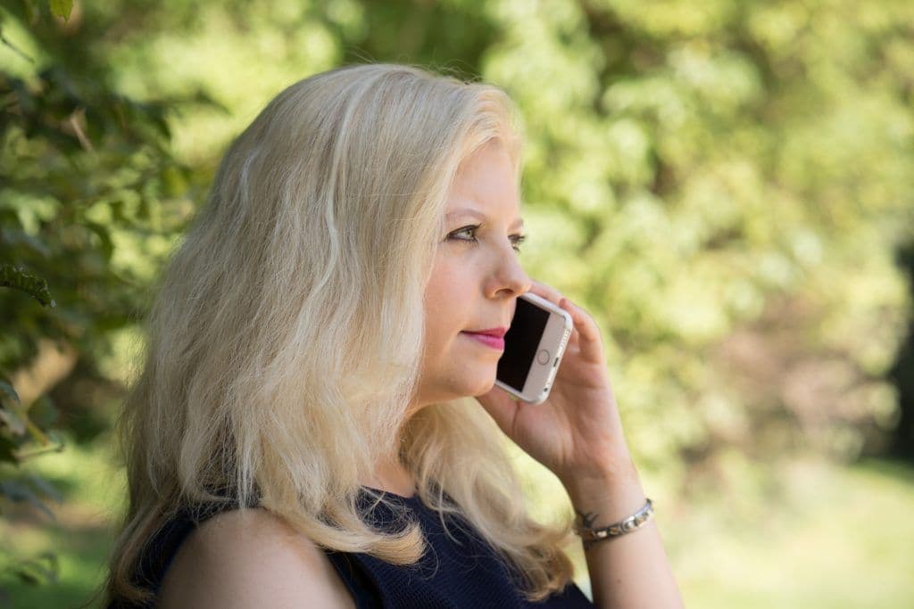 a woman with blonde hair talking on a cell phone