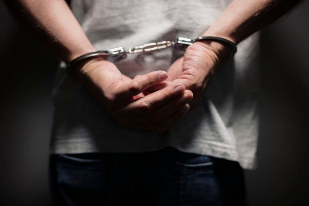 a man holding his hands in handcuffs