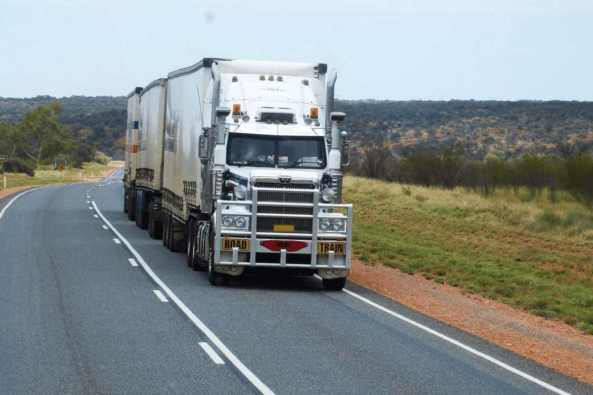 a large semi truck driving down a country road