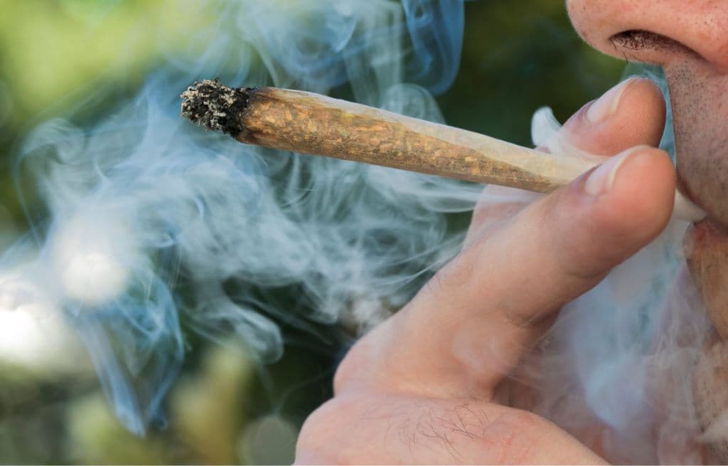 a close up of a person smoking a cigarette