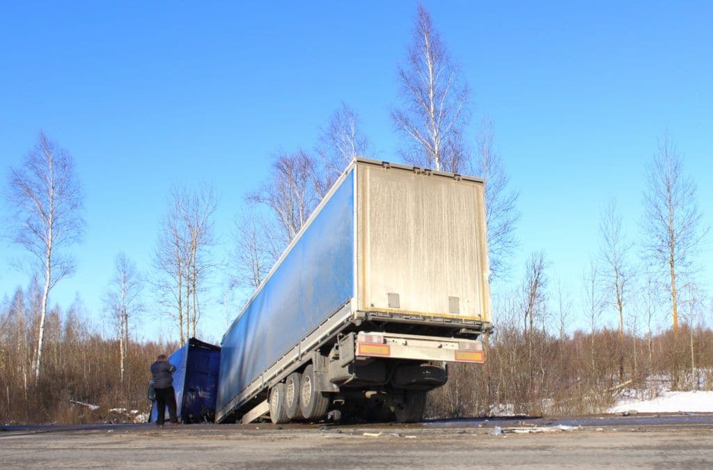 a man standing next to a truck on a road