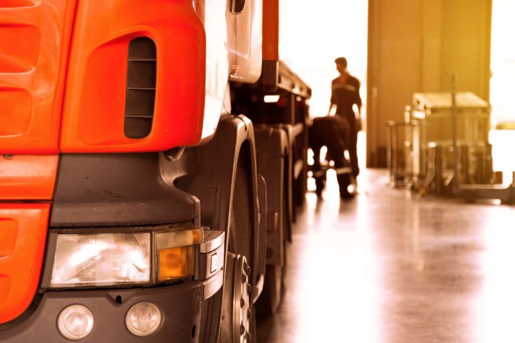 a man walking down a hallway next to a large truck