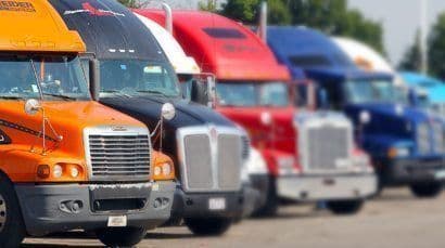 a row of semi trucks parked next to each other