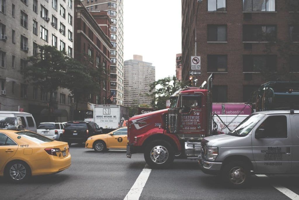 a truck is driving down a busy city street