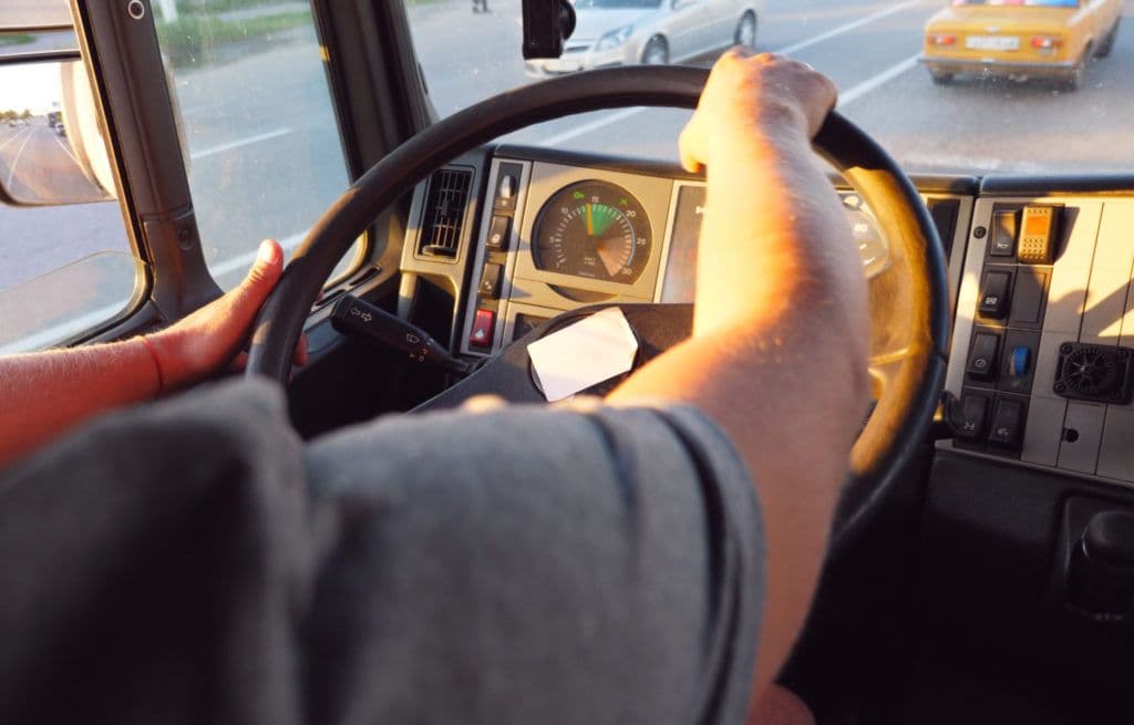 a person driving a bus on a city street