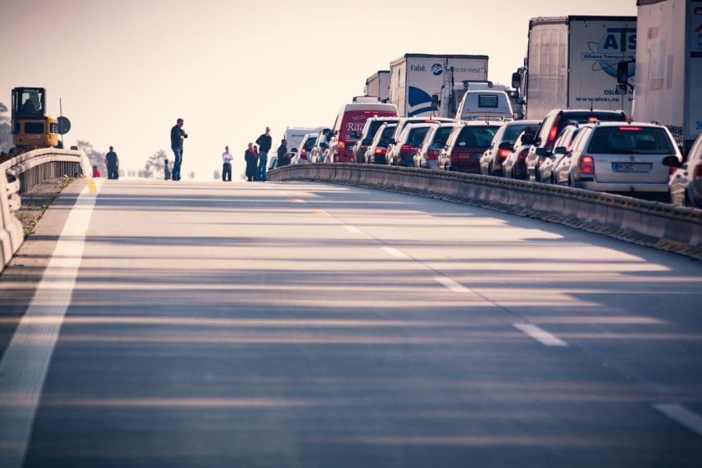 a group of people standing on the side of a road