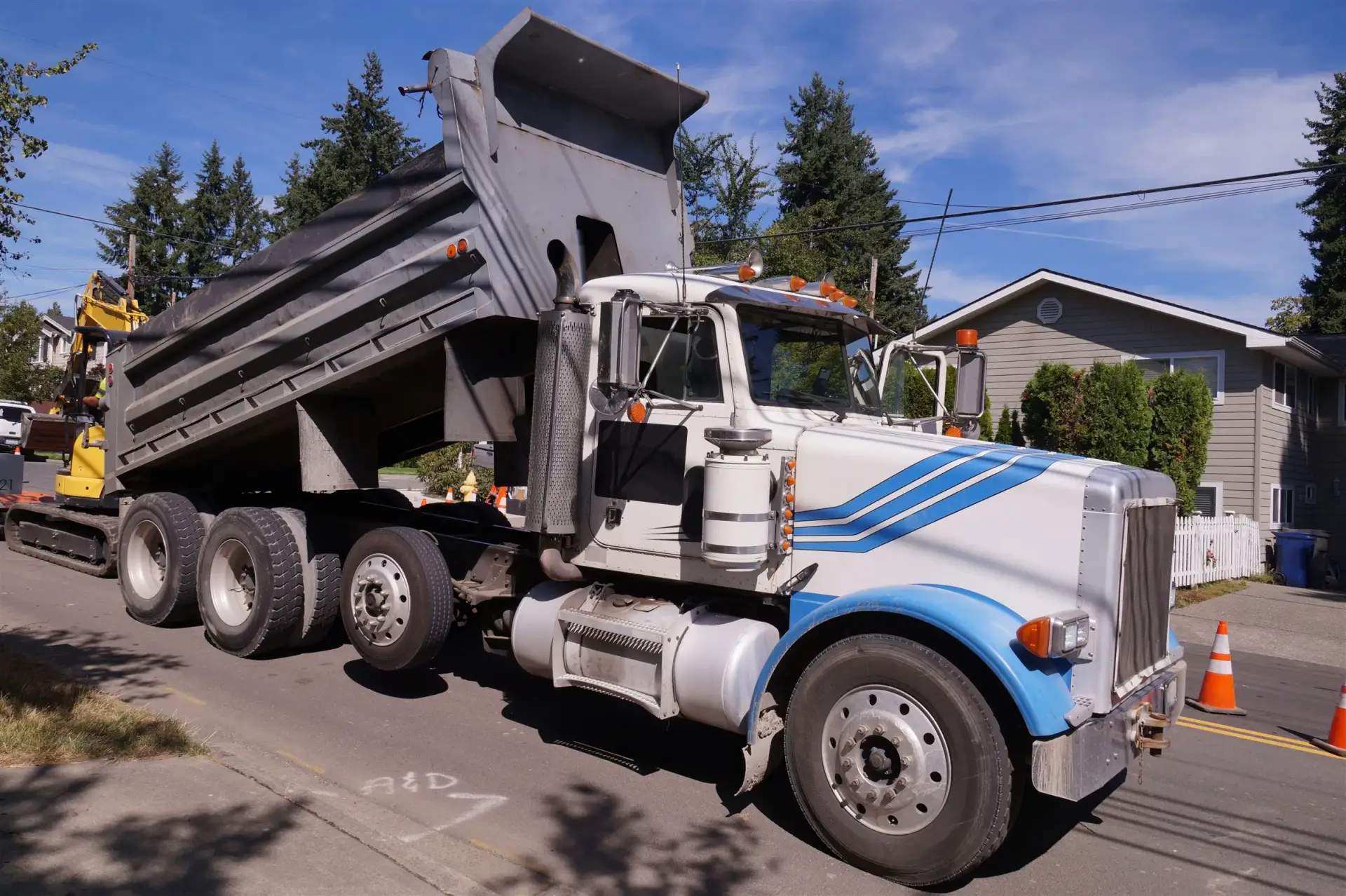 Dump truck with its bed raised at a roadside work zone