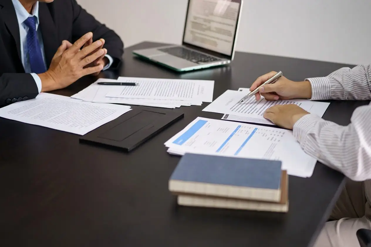 Attorney reviewing case documents with a client at a desk